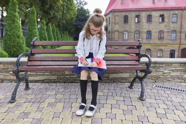 Outdoor portret pięknej dziewczyny z plecakiem pisania w notatniku — Zdjęcie stockowe