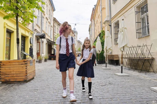 Niños yendo a la escuela, dos hermanas caminando juntas, cogidas de la mano —  Fotos de Stock