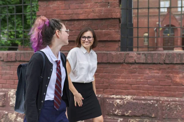 Dziewczyna student nastolatek spacery i rozmowy z kobieta nauczyciel — Zdjęcie stockowe