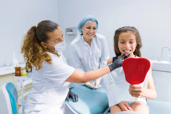 Niña sentada en silla dental tratando dientes — Foto de Stock