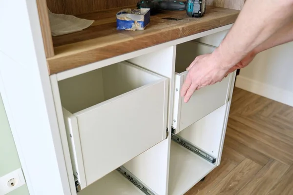 Closeup process of assembling kitchen furniture, hands of male worker — Stockfoto