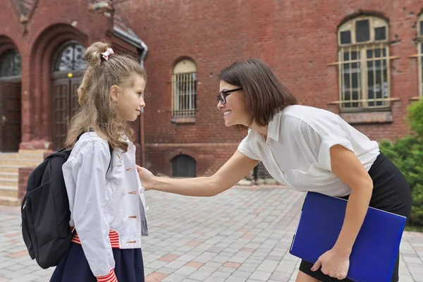 Outdoor portrait of teacher woman and little student girl together — Stok fotoğraf