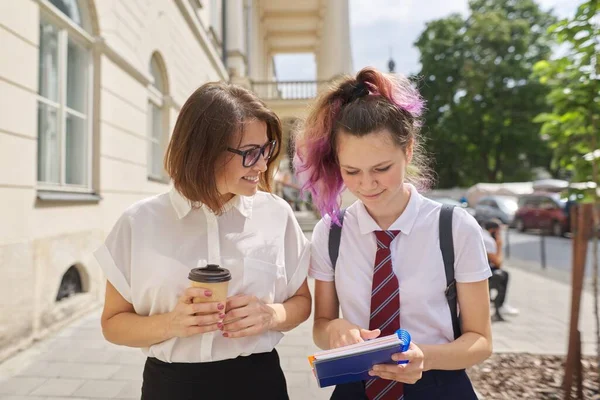 Ходьба і розмова вчителька жінки з чашкою кави і студент підліток — стокове фото