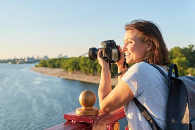 Mature woman photographing with camera, photo journalist, travel blogger