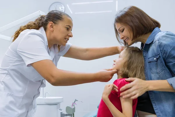 Mother and child girl in meeting with doctor orthodontist — Stockfoto