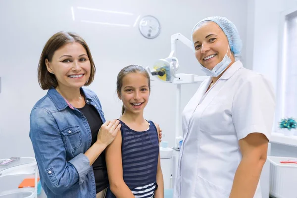 Happy mother and child in office with dentist doctor after dental treatment — Stockfoto