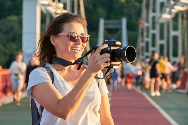 Зріла жінка-фотограф з фотоапаратом робить фотографію — стокове фото