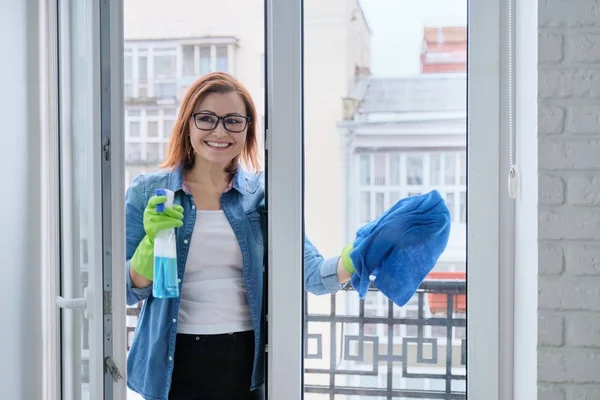 Mature woman cleaning windows at home in spring — Stock Photo, Image