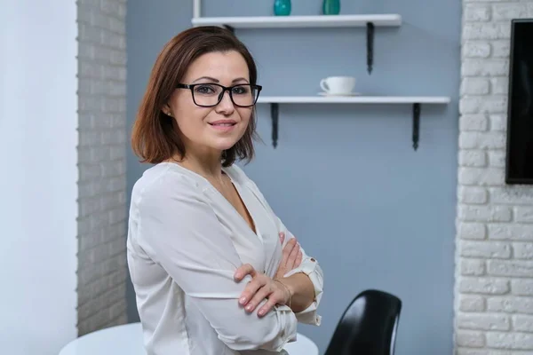 Portrait of positive confident middle aged woman with arms crossed — Stock Photo, Image