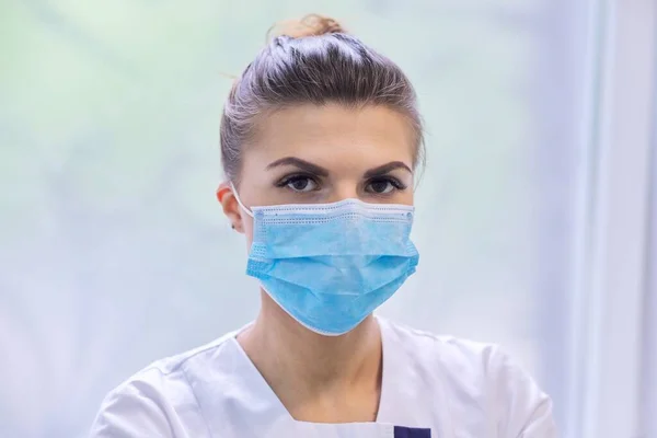 Retrato de una joven enfermera doctora en mascarilla médica protectora — Foto de Stock