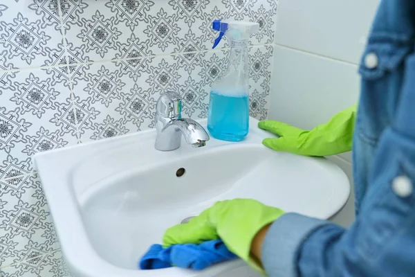 Femme mains nettoyage et polissage lavabo et robinet dans la salle de bain — Photo