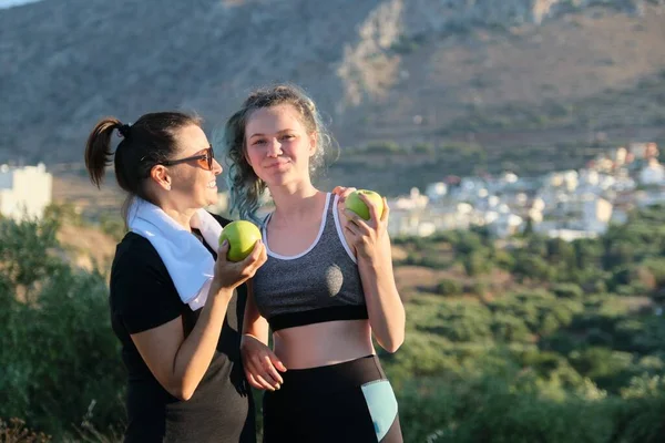 Twee vrouwen moeder en tienerdochter drinken water op hete zomerdag — Stockfoto