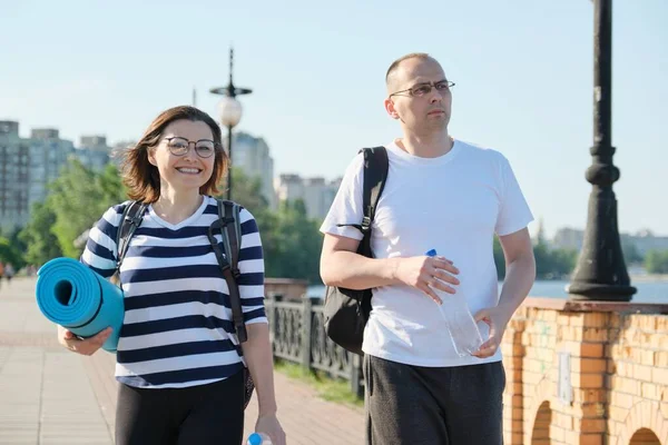 Parler homme et femme d'âge moyen, couple marchant le long de la route du parc — Photo
