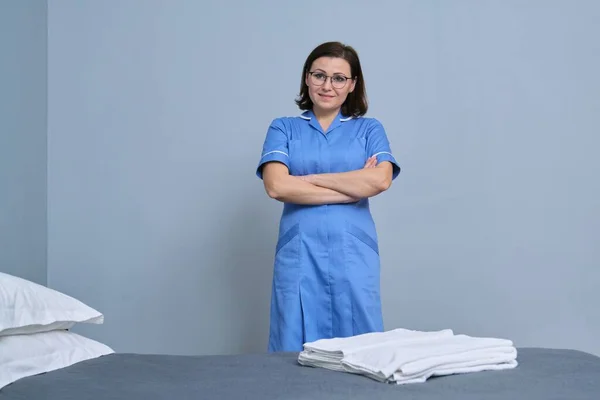 Retrato de mulher madura, equipe de limpeza do hotel com toalhas frescas no quarto do hotel — Fotografia de Stock