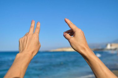 El hareketlerini gösteren eller, mavi gökyüzü arkaplanı