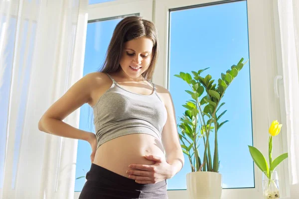 Portrait of beautiful pregnant woman touching belly with hands — Stock Photo, Image