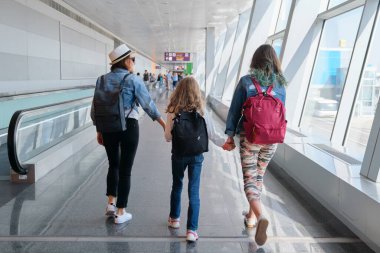 Havaalanı terminali içeride, yolcuları bavullarıyla gezdiriyor.