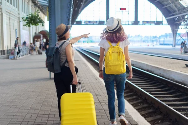 两名母亲和少女带着行李在火车站走着 等火车到达的人 — 图库照片