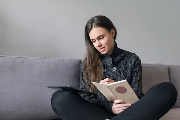 Mujer Joven Sentada Casa Sofá Con Gadgets Teléfono Inteligente Lectura —  Fotos de Stock