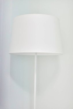 Beyaz, modern, beyaz iç döşemeli bir lamba. Döşeme lambasının tepesine yakın tekstil..