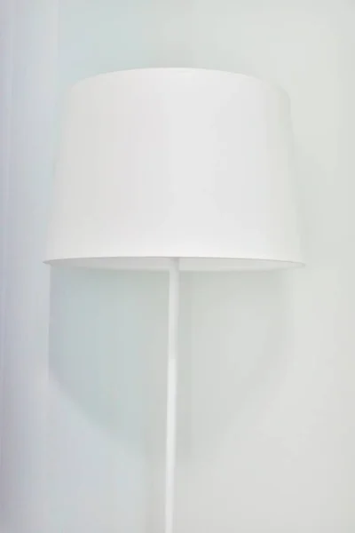 White elegant modern floor lamp in white interior. Closeup textile top of floor lamp.