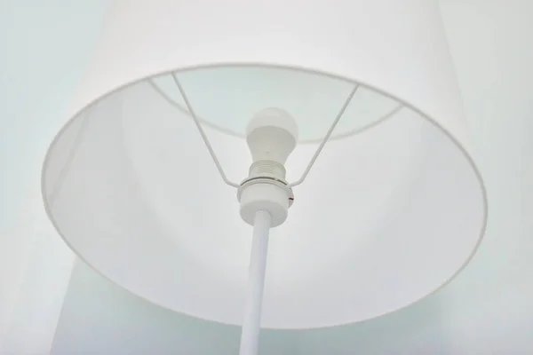 White elegant modern floor lamp in white interior. Closeup textile top of floor lamp.