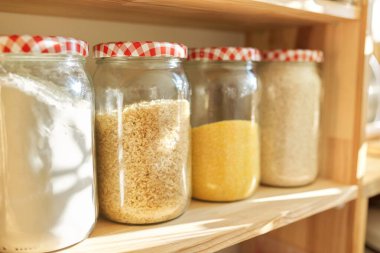 Kilerde yiyecek depolamak için ahşap raflar, saklama kavanozlarında tahıl ürünleri.