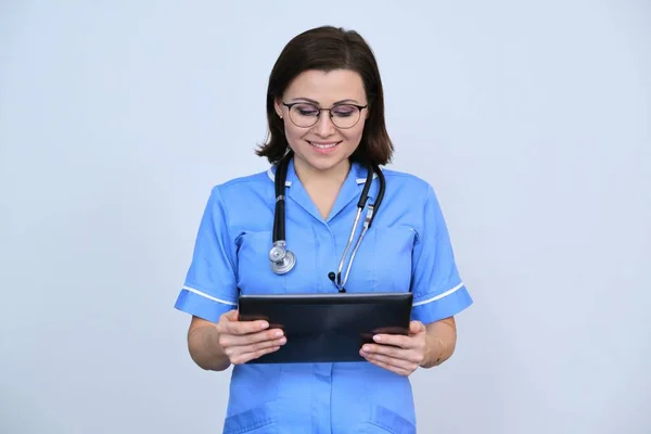 Médica Meia Idade Com Tablet Digital Enfermeira Sorrindo Olhando Para — Fotografia de Stock