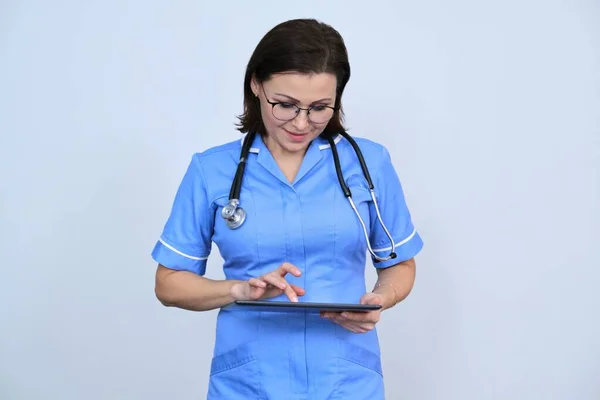 Médica Meia Idade Com Tablet Digital Enfermeira Sorrindo Olhando Para — Fotografia de Stock