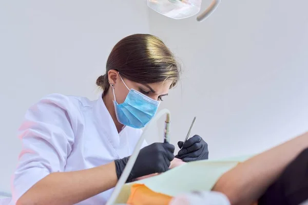 Mujer médico dentista tratamiento de dientes a niña paciente en el consultorio dental — Foto de Stock