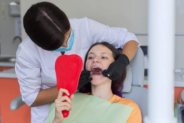 Дівчина-підліток лікує зуби в стоматологічному кабінеті, консультація ортодонта — стокове фото