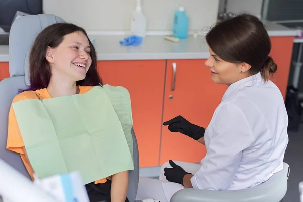 Дівчина-підліток лікує зуби в стоматологічному кабінеті, консультація стоматолога-ортодонта — стокове фото