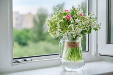 Bahar zamanı, vadinin taze nilüferleri, pembe güller, çiçek açan viburnum. Pencere pervazında cam sürahi, açık pencere arkaplanı