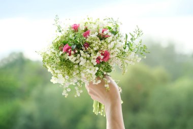 Güzel, taze bir çiçek buketi, pembe gül, kadın elinde yeşil dallar. Çiçekçilik, çiçekçilik, güzellik.