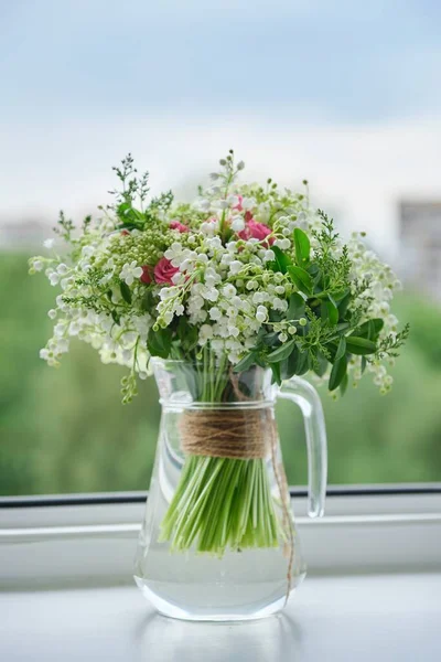 谷のユリの春の新鮮な花束 ピンクのバラ ビブラムを咲かせます 窓辺のガラスのジャグの花束 開いているウィンドウの背景 — ストック写真