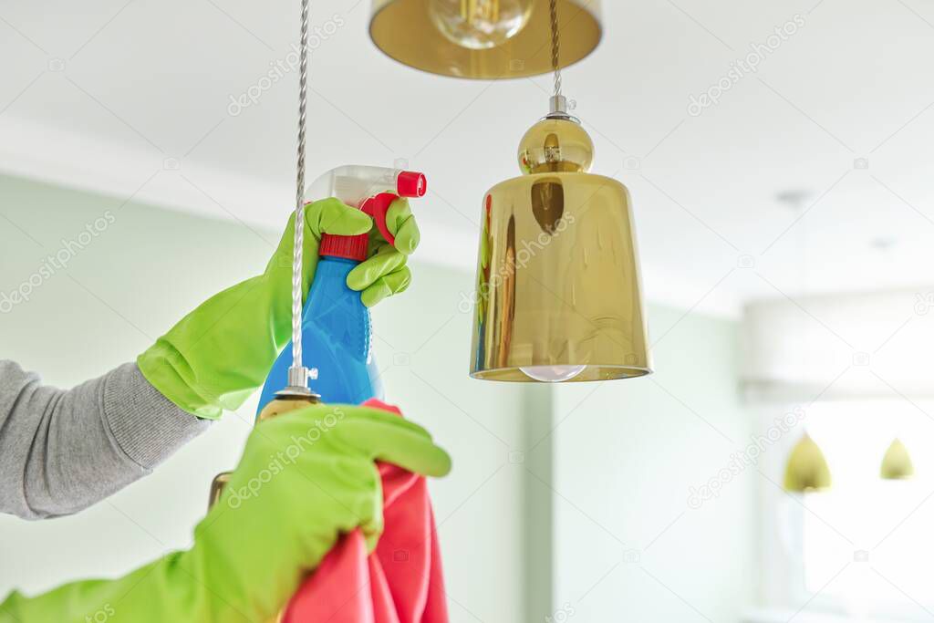 House cleaning, close-up of hands with rag detergent, cleaning and polishing lamp, chandelier