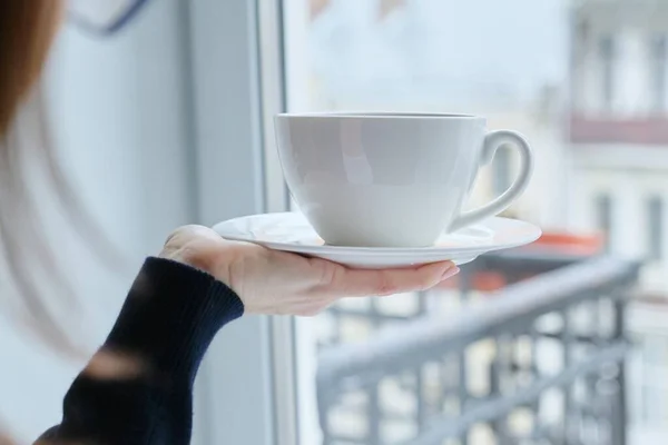 女性の手にソーサー上の磁器の白いカップ セット — ストック写真