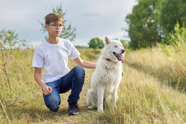 Outdoor portrait of boy teenager with white dog — Stock Photo, Image