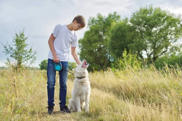 Portrait extérieur de garçon adolescent avec chien blanc — Photo