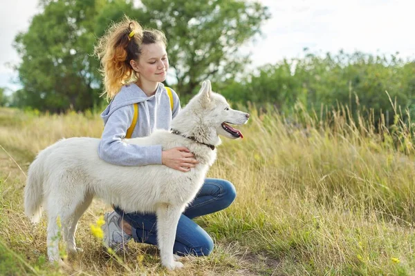 Adolescent fille étreinte chien, amitié soins et amour entre enfant et animal de compagnie — Photo