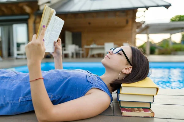 Okos tini lány szemüvegben olvasás könyv, tinédzser közel ház — Stock Fotó
