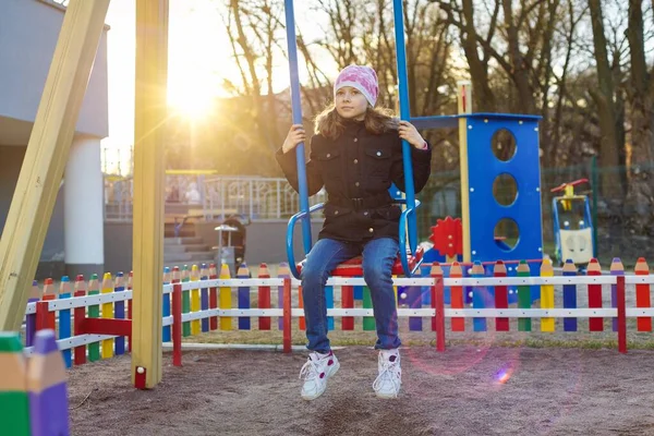 Girl child 8, 9 years old on swing, childrens playground — Stock Photo, Image