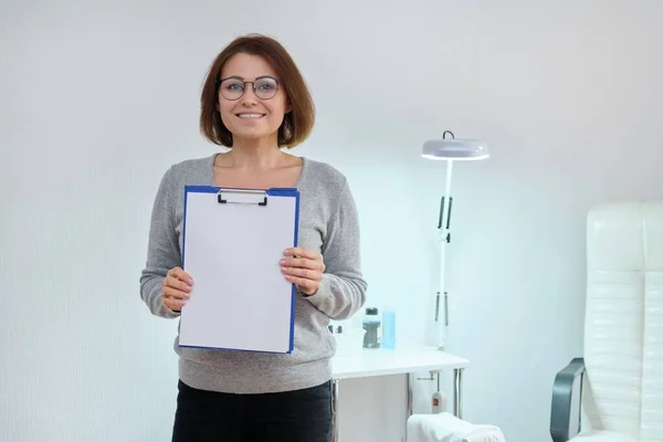 Rijpere zakenvrouw met blanco papier op een klembord, plaats voor advertentie tekst — Stockfoto