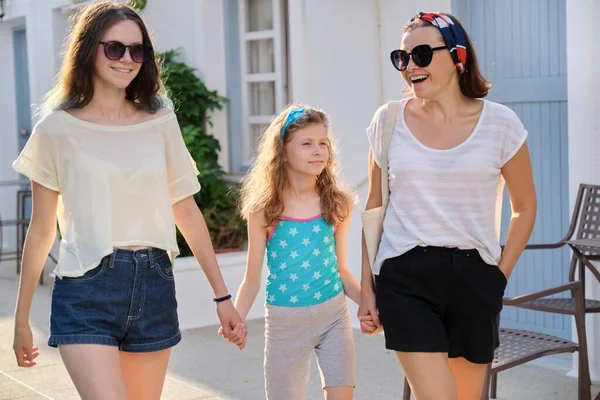 Мать и две дочери подросток и младшая идут вместе, держась за руки — стоковое фото
