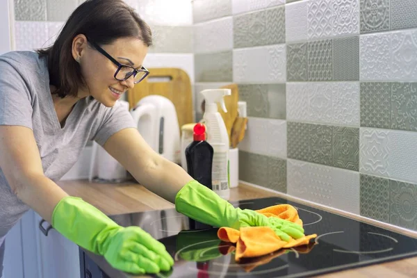 Donna mano nei guanti pulizia cucina elettrica piano cottura in vetroceramica — Foto Stock