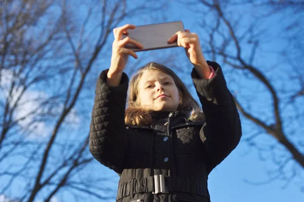 Outdoor portrait girl child of 8, 9 years old with smartphone — Stock Photo, Image