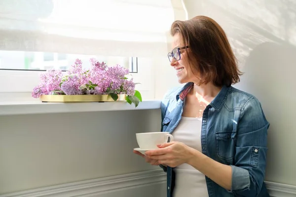 Retrato de mujer de mediana edad en casa con flores — Foto de Stock