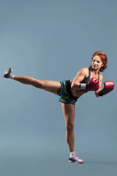 Reife Frau in Sportbekleidung macht Fitnessübungen in Boxhandschuhen — Stockfoto