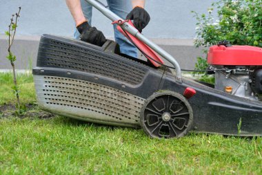 Çim biçme makinesi yeşil çimenlikte çalışıyor.