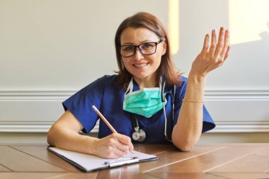 Web kamerasına bakan kadın doktor, video konferansı